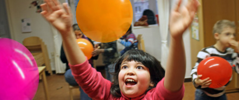 Finkenkrug Schule Kind spielt strahlend mit Luftballons