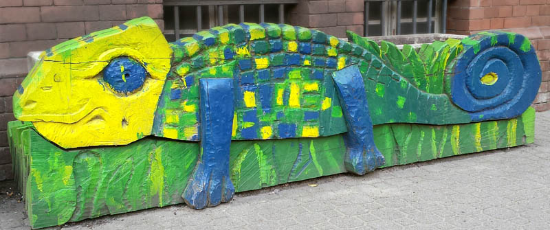Schulbezogene Sozialarbeit an der Leo-Lionni-Grundschule, Berlin im Bezirk Mitte, Ortsteil Wedding, bunt bemalte Holzskulptur am Eingang